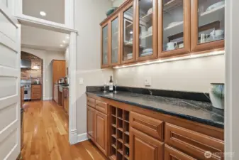 The butler’s pantry with display glass cabinetry serves as the pass through into the spacious kitchen.