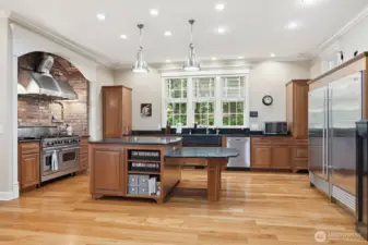 The spacious kitchen which features warm cherry cabinetry, slab soapstone counters, huge island with seating.
