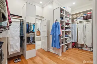 The oversized walk-in closet with built-ins features a retractable ladder to the vast attic storage room above.