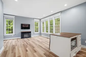 The bonus room features engineered hardwood floors, an island with seating and microwave.