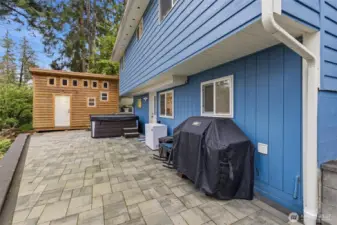 Driveway and back patio features lighting under wall cap. Staircase beyond  hardscape to firepit.