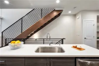 Stairs from the lifestyle level to the upper bedroom level are custom constructed and stained.  Metal railings add to the contemporary look.  The open stairs are a unique feature of these homes and allow natural light to flood through them.