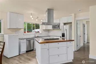 The kitchen features stainless appliances and looks out over the private backyard.