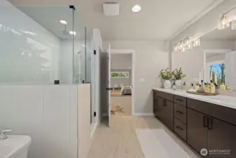 Luxurious bathroom in Owner's Suite with double sinks, walk-in shower with dual showerhead system, and lounge tub.