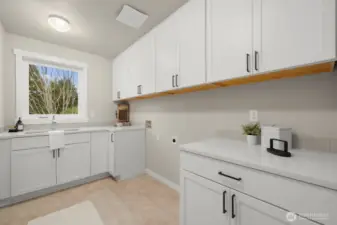 Upper level laundry with folding counter and utility sink.