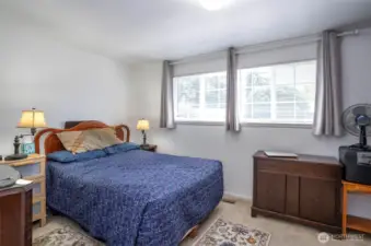 The primary suite boasts two oversized windows that fill the room with natural light.