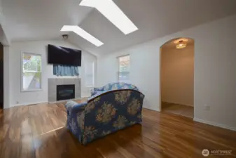 Entry opens up to Large living space with fireplace and skylights