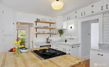 Kitchen was remodeled with butcher block island, gas range, quartz countertops, a vintage farm sink and more!