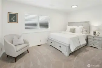 Tranquil main-level bedroom with plush carpet, plantation shutters, custom closet system and neutral tones - ideal guest space or home office in this Sammamish lakefront gem
