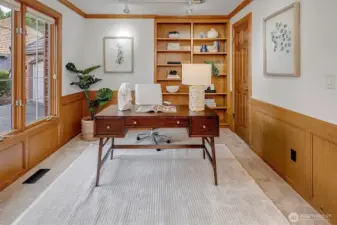 Main level den with built in book shelves and wood wainscoting