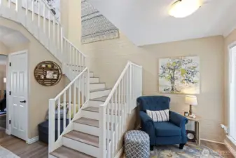 A spacious entry has enough room for a sitting area, This makes putting shoes on and off easy when coming and going. Light floods the staircase from the skylights above.