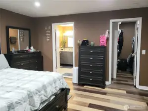 Another View of the Primary Master Bedroom Showing New Paint, Trim Led Lighting and Vinyl Plank Flooring Looking at the Entrance to the Bathroom and Walk In Closet.