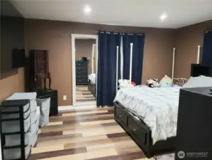 An Opposite View of the Primary Master Bedroom Showing New Paint, Trim Led Lighting and Vinyl Plank Flooring.