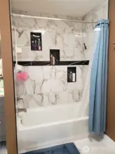 Full View of the Main Gust Bath Tub and Floor to Ceiling Tile Surround and Tile Flooring.