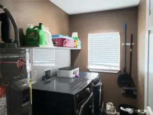 Nice Size Utility Room with Newer Washer, Dryer, Paint Trim, Shelf and Hot Water Tank.