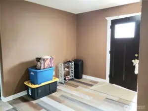 A View of the Front Entry Door Foyer with New Paint, Trim and Vinyl Plank Flooring.