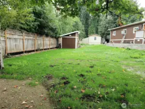 Another View of the Huge Back Yard of the Home with New Deck and Retaining Wall showing the New Dry Storage Shed.