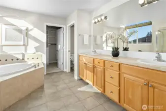 Primary 5-piece bathroom with double vanity, soaking tub, walk-in shower, and WIC. Ceramic tile floor.