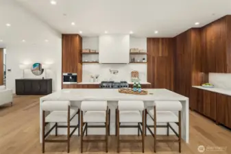 The chef's kitchen is nothing short of a masterpiece. Wolf appliances, slab marble countertops, rich walnut cabinetry with European styling, and a cleverly concealed pantry combine beauty with serious culinary function.