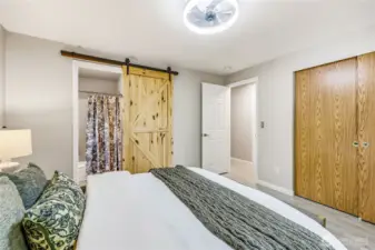 Primary bedroom with barn door leading into the private bathroom.