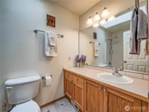 Full bathroom in hall with skylight