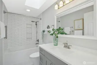 Updated guest bath with a light flooding skylight.