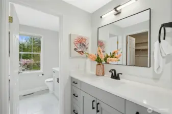 beautiful spa-like remodeled bath room offering tile floors and a walk-in closet.