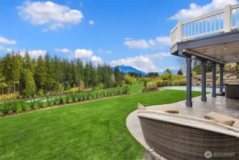 Expansive lawn with in-ground sprinklers backs to the 8th fairway.