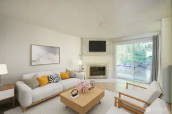 The spacious living area includes a wood burning fireplace The patio faces green space with mature trees and plantings.