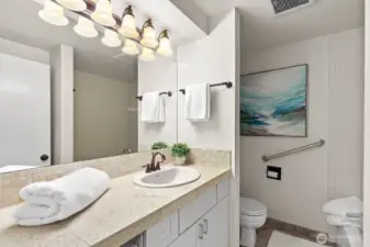 Well lighted bath with tile counter and backsplash.
