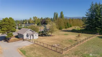 Drone shot where the little fenced side yard is shown.  Then a fenced backyard.