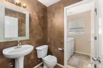 Main floor half bath leading into the laundry room.