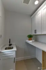 Laundry Room with sink, cabinets and shelf.