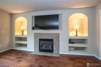 A cozy gas fireplace anchors the family room, while built-in shelving and architectural niches offer the perfect space for décor, entertainment systems, or personal touches.