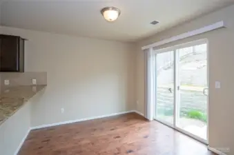 Another view of the dining area with convent sliding door leading to the private fenced, terraced backyard.