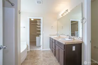Expansive primary bathroom with dual vanities, soaking tub, and separate shower.