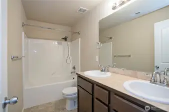 The upper-level full guest bath offers dual vanities—perfect for busy mornings.
