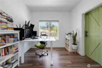Bright and open office space with barn door for privacy.