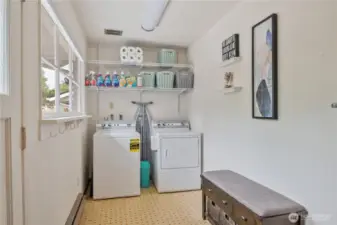 Spacious mud room/utility opens to the back yard