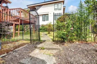 Expensive wrought iron fencing defines the yard spaces. This is the North property boundary.