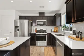 Kitchen features Quartz slab counter tops, tile backsplash and stainless steel appliances