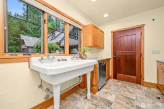 Laundry room off kitchen, with American country sink, leads to undercover breezeway to 3 car garage with EV hook up