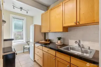 Cozy kitchen featuring tall ceilings, natural light, and plenty of storage—perfect blend of classic and practical.