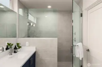 Connect to your primary bedroom is a luxury bath. Walk-in shower with half-wall for privacy & glass door. Tile rides all the way up the wall making cleaning a breeze whilst tying together the luxury appearance.