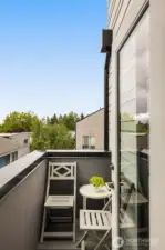 Cozy primary balcony, perfect for reading with a coffee.