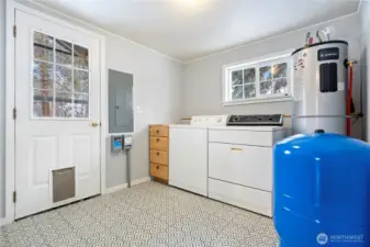 Laundry room w/ new water heater and pressure tank, light, and door to backyard