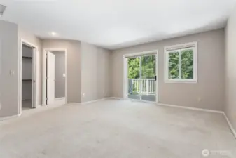 Bright and airy primary bedroom with sliding doors that open to a private deck space.