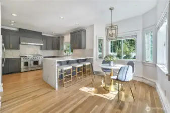 There is plenty of space to entertain in this large, updated kitchen that feature new cabinetry, quartz countertops and backsplash, refinished hardwood floors, 48" gas stove, and updated light fixtures.