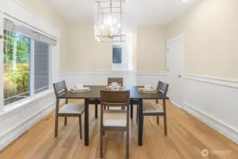 The dining room is attached to the formal living space and features updated paint and light fixture.
