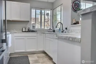 The kitchen is updated w/ laminate counters, raised panel cabinets and laminate tile flooring. Stainless appliance complement the kitchen's design.